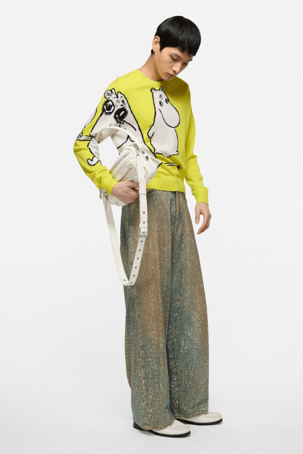 Chłopak w limonkowym swetrze Acne Studios z Muminkami i połyskujących spodniach