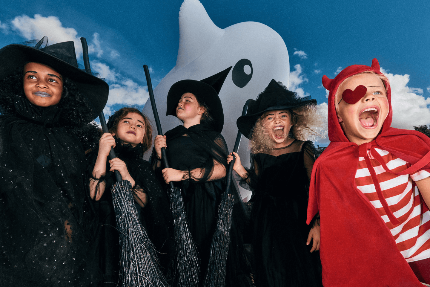 Dzieci śmieją się i krzyczą. Ubrane są w stroje wiedźm i diabełka.